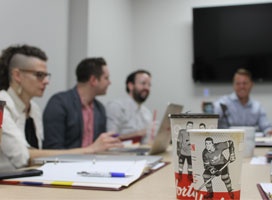 Coffee cups with hockey players in foreground, researchers in background