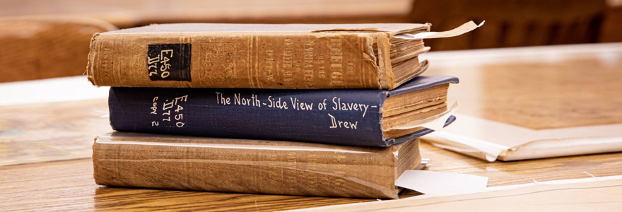 Stack of books, including Benjamin Drew's book "A North-Side View of Slavery" 